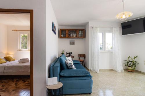 - un salon avec un canapé bleu et un lit dans l'établissement Villa Planka Pearl, à Ražanj