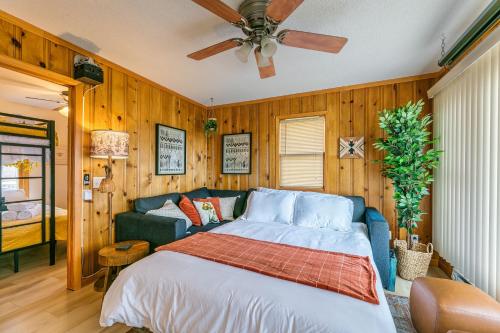 a bedroom with a bed and a couch and a ceiling fan at Lakefront, wildlife Cabin retreat - Sauna optional in Lindstrom