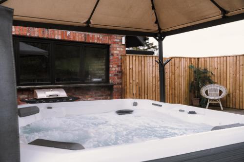 a large white bath tub sitting under an umbrella at Luxury Retreat -Perfect To Explore The North Coast in Macosquin