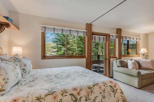 a bedroom with a bed and a couch and windows at Laurelwood Condominiums 205 in Snowmass Village