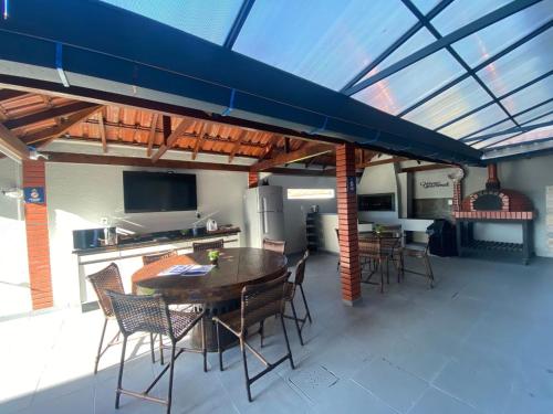 a patio with a table and chairs and a kitchen at Pousada Recanto Forte in Florianópolis