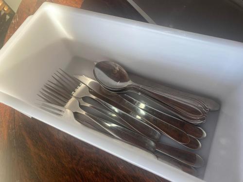 a white container withsilver utensils in a drawer at Pousada Recanto Forte in Florianópolis