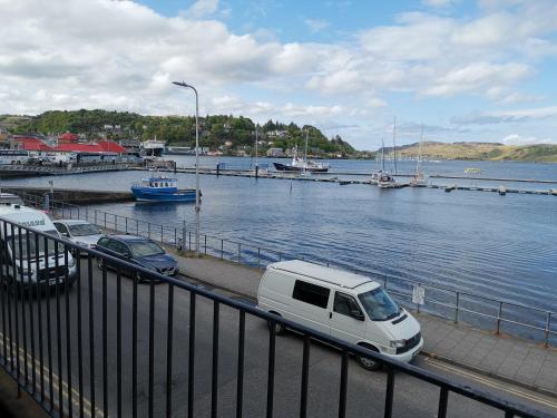 a white van parked next to a body of water at bayviewapartment in Oban