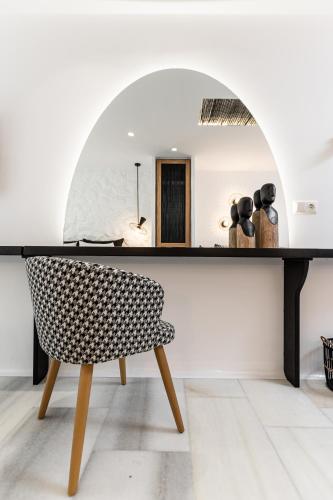 a chair in front of a table with a mirror at Anatoli Hotel in Naxos Chora