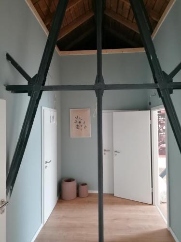 a room with white walls and black beams at Meisterhaus Apartment 8 in Glauchau