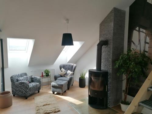 a living room with a fireplace and a chair at Meisterhaus Apartment 8 in Glauchau