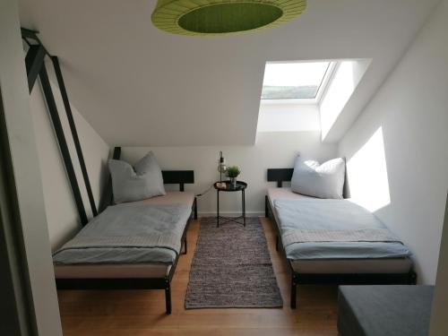 two beds in a room with a skylight at Meisterhaus Apartment 8 in Glauchau