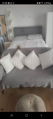 a bed with white pillows on top of it at Jaskar studio 2 in Cheltenham