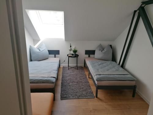 a attic room with two benches and a window at Meisterhaus Apartment 8 in Glauchau