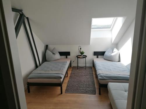 a attic room with two beds and a couch at Meisterhaus Apartment 8 in Glauchau