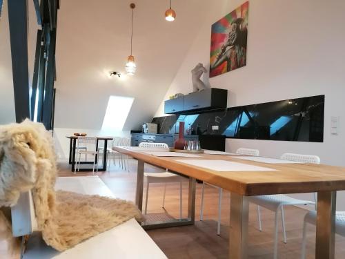 ein Esszimmer mit einem Holztisch und Stühlen in der Unterkunft Meisterhaus Apartment 8 in Glauchau