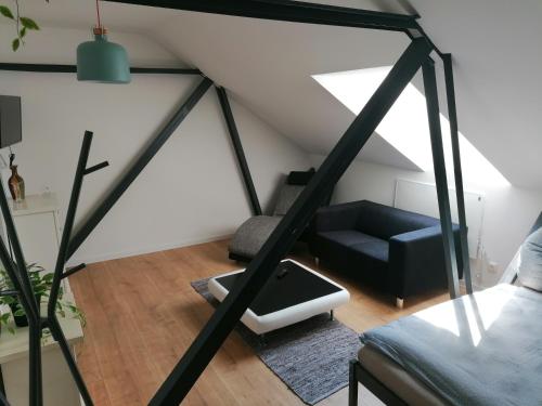 a living room with a black couch and a chair at Meisterhaus Apartment 8 in Glauchau