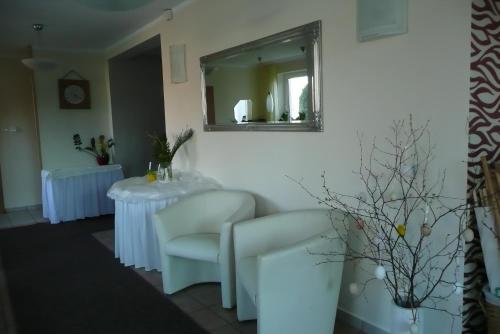 a salon with two chairs and a mirror at Pensjonat Landrynka in Darłówko