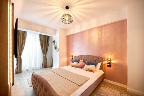 Un dormitorio con una cama grande y una lámpara de araña. en La Mer by Infinity Resort & SPA en Mamaia-Sat