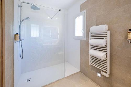 W łazience znajduje się prysznic i białe ręczniki. w obiekcie Hotel La Garbine w Saint-Tropez