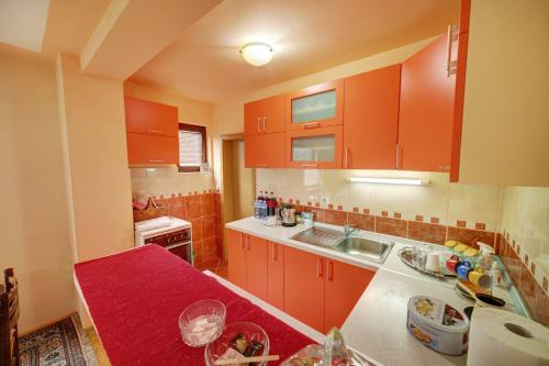 Pribojska Banja的住宿－Smestaj Rakovic，厨房配有橙色橱柜和红色台面