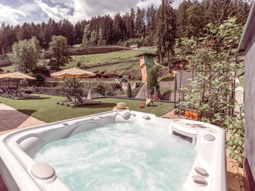 a large hot tub in a backyard with a garden at Alpin Family Resort Seetal in Kaltenbach