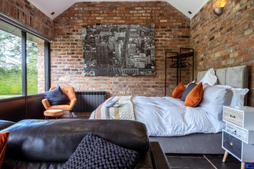 a living room with a couch and a brick wall at Luxury Retreat -Perfect To Explore The North Coast in Macosquin