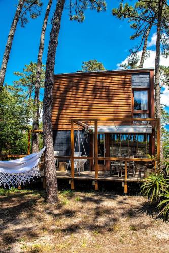 a wooden house with a hammock in a forest at Bungalow B1 em Fão - Ofir by Ana Ferro Rentals in Ofir