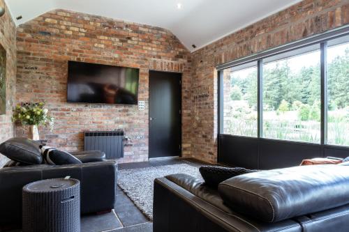 a living room with a couch and a brick wall at Luxury Retreat -Perfect To Explore The North Coast in Macosquin