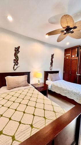 a bedroom with two beds and a ceiling fan at Monte Carlo Luxury Condominiums in Jacó