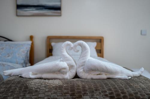 two towelsrendered to look like swans on a bed at Personal En-suite in Shrewsbury