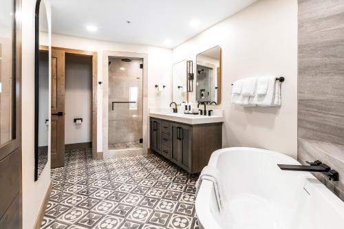 uma casa de banho com uma banheira, um lavatório e um chuveiro em Canyons Village Condos by All Seasons Resort Lodging em Park City