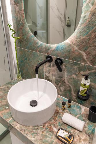 a bathroom with a sink and a mirror at Bella Vasilica Luxury Apartments in Parga