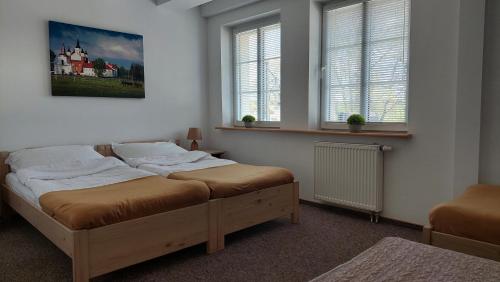 1 dormitorio con 2 camas y 2 ventanas en Willa Centrum en Supraśl