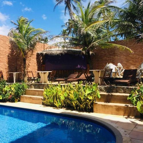 a resort with a swimming pool and palm trees at Hana Praia Hotel in Camocim