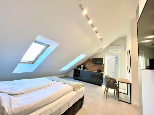 una camera mansardata con letto e finestra di Apartament VIP Sztutolo z basenem a Sztutowo