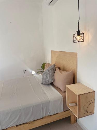 a person laying on a bed with a night stand at Anana Coliving in Playa del Carmen