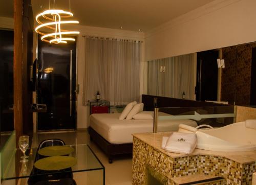 um quarto de hotel com uma cama e uma banheira em VERT MOTEL MOSSORO em Mossoró
