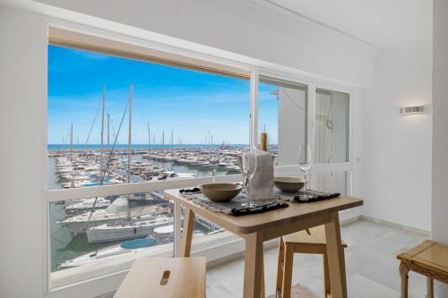 een keuken met een groot raam met uitzicht op een haven bij luxurious frontline penthouse in puerto banus in Marbella
