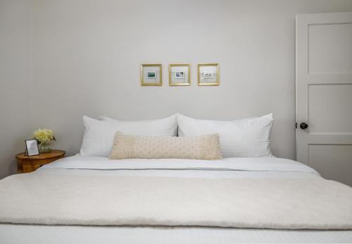 a white bedroom with a white bed with white pillows at Immaculate Charming Duplex-1Unit in Oroville