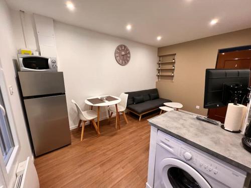 cocina y sala de estar con sofá y mesa en Arcueil : 2P Moderne & Neuf. Proche RER B., en Arcueil