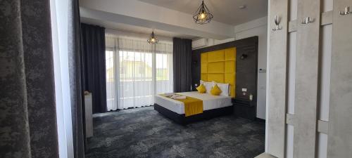 a bedroom with a bed with a yellow headboard at YAMADA in Năvodari