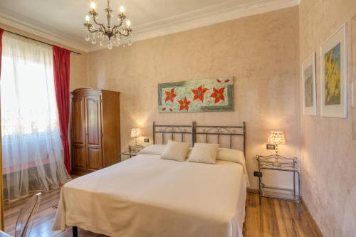 a bedroom with a large white bed and a chandelier at Locanda Villa Moderna in Genoa