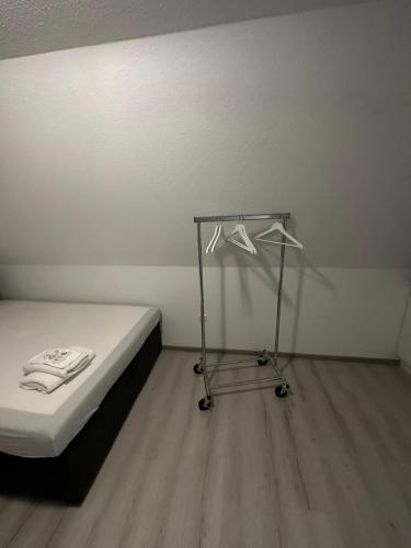 a bedroom with a bed and a metal rack with hangers at City Living 2 in Schwäbisch Hall