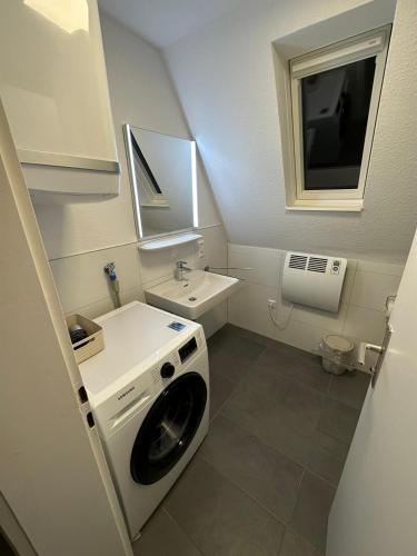 a small bathroom with a washing machine and a sink at City Living 2 in Schwäbisch Hall