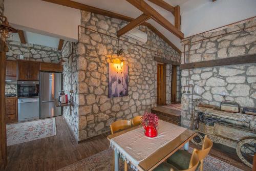 a kitchen with a table and a stone wall at Kalabantia House in Fethiye