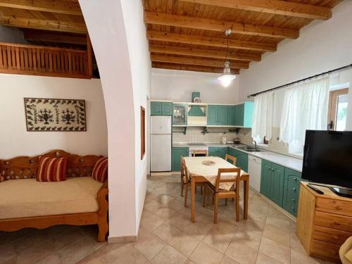 a kitchen with green cabinets and a table in a room at Kostas Village House in Psinthos