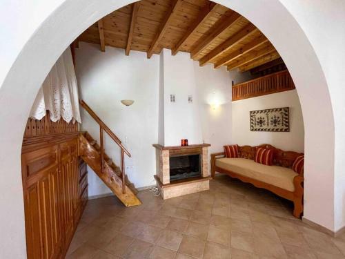 a living room with a couch and a fireplace at Kostas Village House in Psinthos