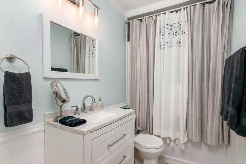 a white bathroom with a sink and a toilet at The Green Bench Cottage - Pet Friendly in St. Petersburg