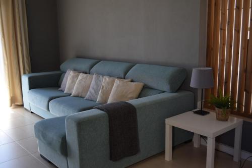 a blue couch in a living room with a table at Family House in Lagos