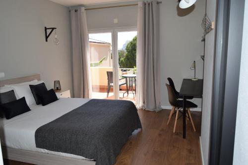 a bedroom with a bed and a balcony with a table at Family House in Lagos