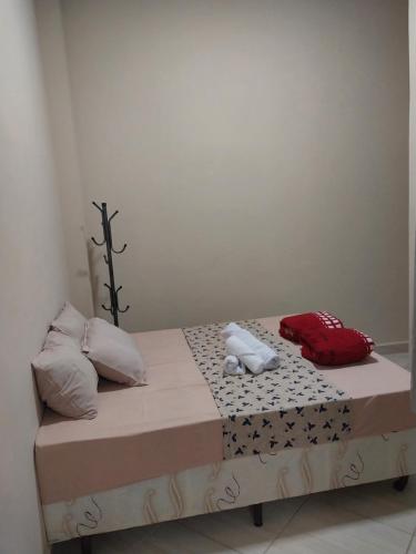 a bed with two pillows on top of it at Aparecida Akuto's Pousada in Aparecida