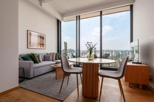 a living room with a table and chairs and a couch at Londres 256 by Wynwood House in Mexico City
