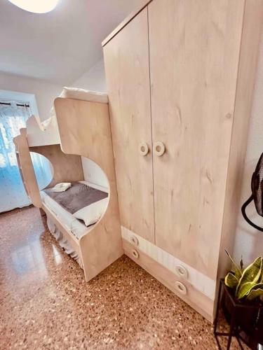a wooden cabinet with a bunk bed in a room at Citadella Apartment in Puerto de Sagunto