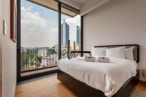 a bedroom with a large bed and a large window at Londres 256 by Wynwood House in Mexico City